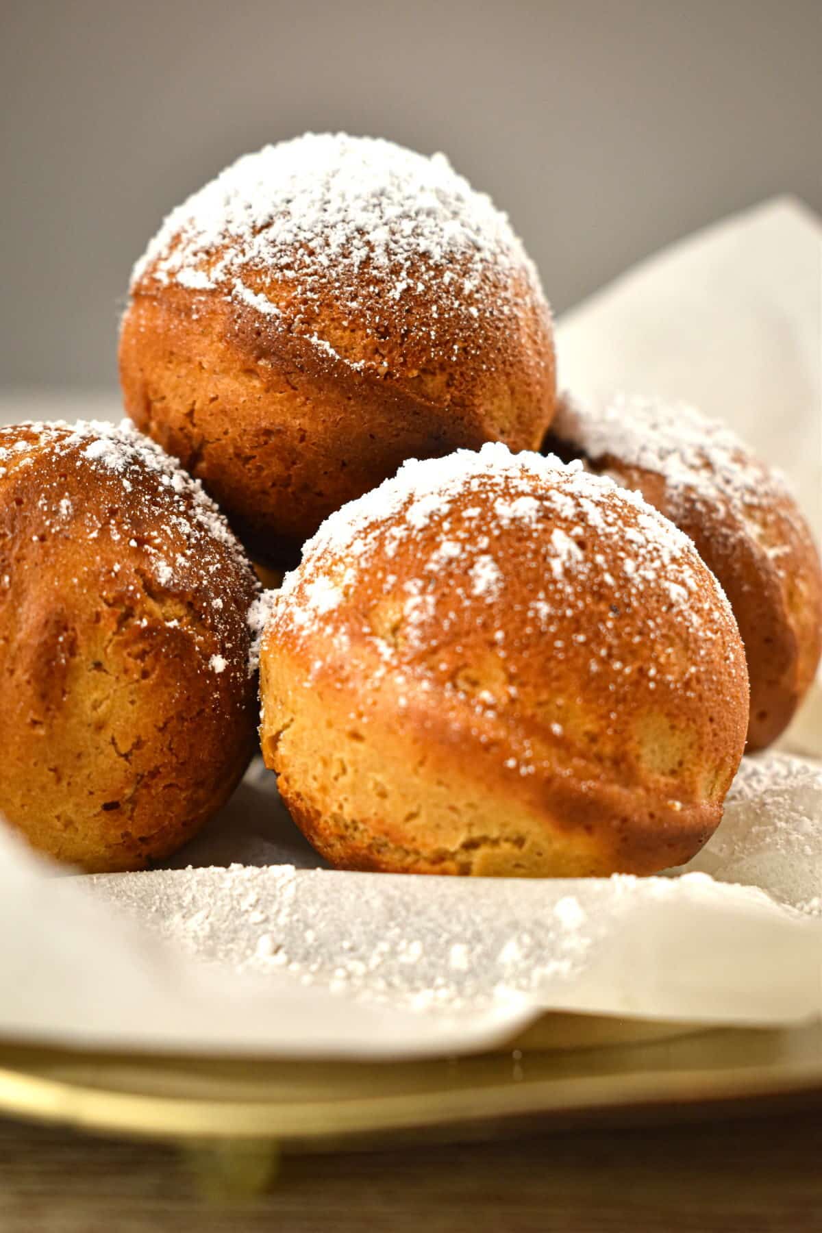 Gingerbread cake balls on parchment, covered in powdered sugar close up.