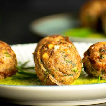Mediterranean meatballs with dill sauce on plate.