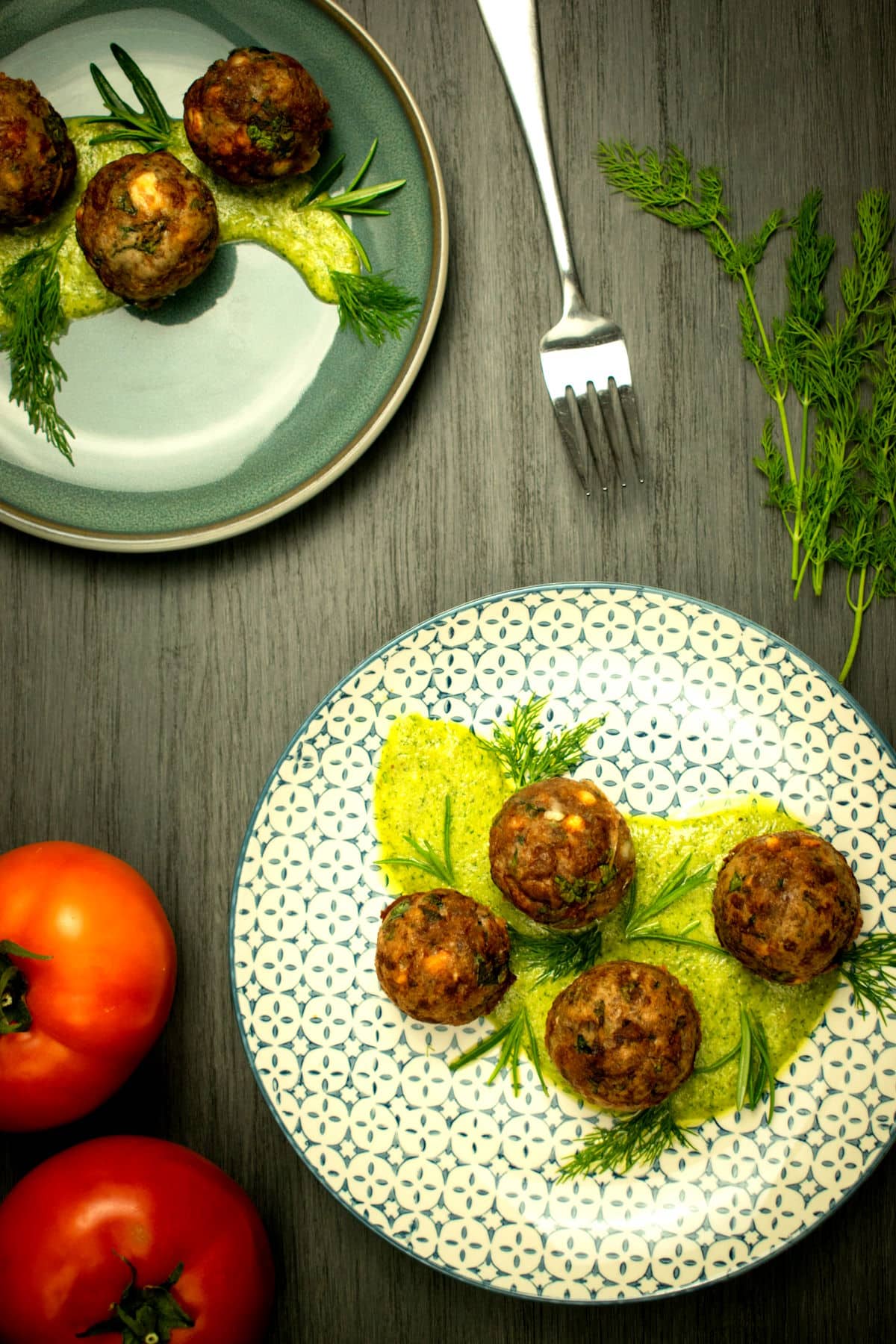 Mediterranean meatballs with dill sauce on decorative plate.