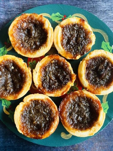 Canadian butter tarts on Christmas themed plate.