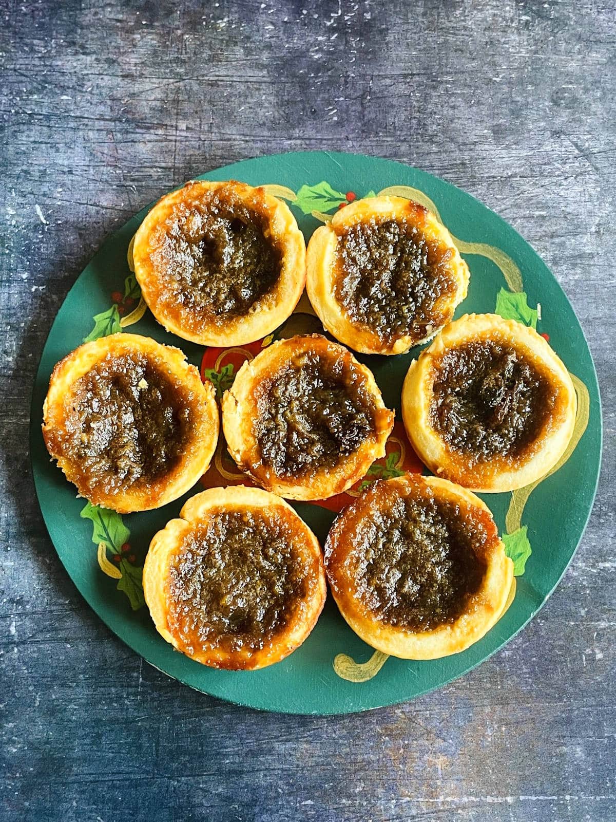 Canadian butter tarts arranged on holiday themed plate.