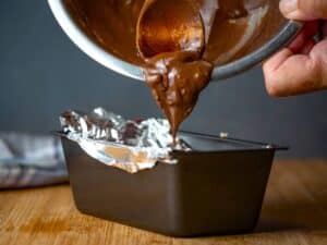Melted chocolate pouring into loaf pan.
