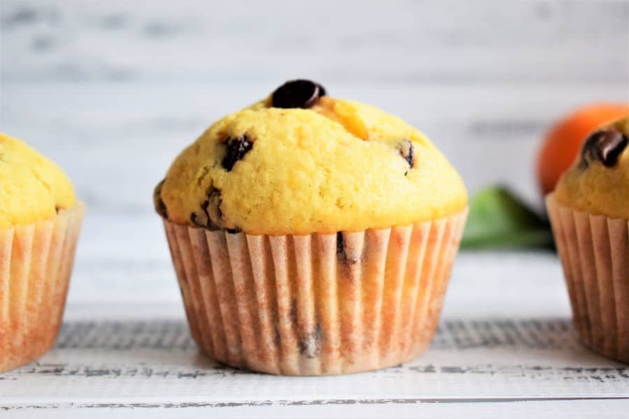 Chocolate Chip Orange Zest Muffins on white wooden background.