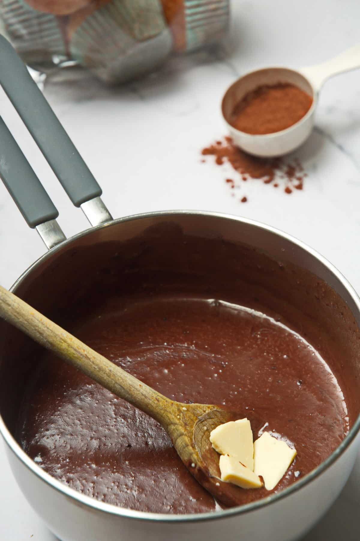 Chocolate gravy in a saucepan with wooden spoon.