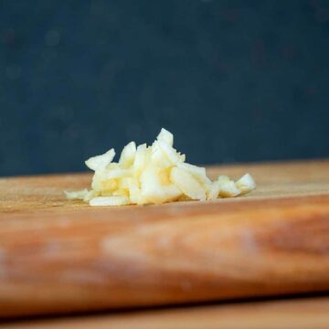 Chopped garlic on cutting board.