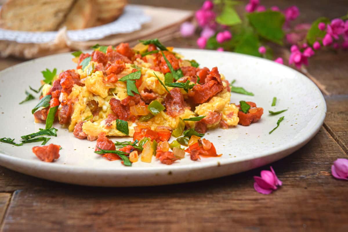 Chorizo and egg scramble on a white plate with parsley.