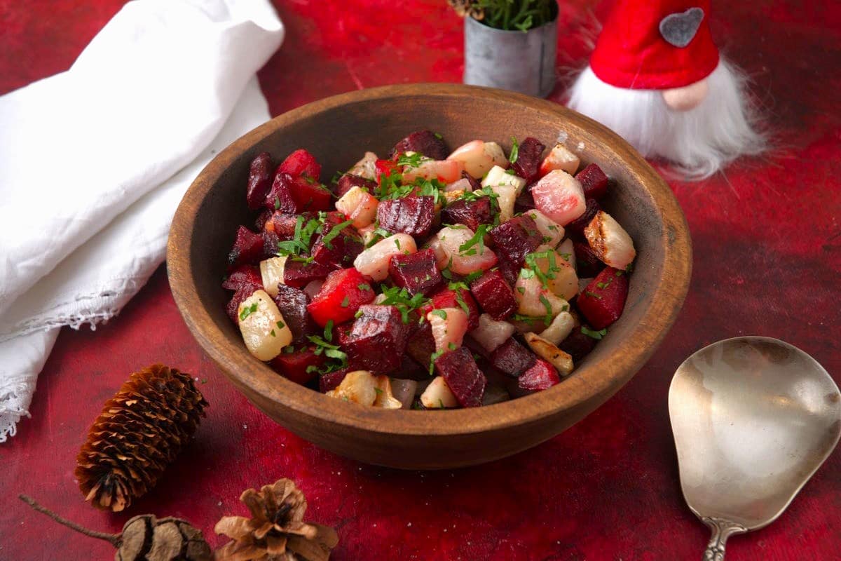 Roasted beets, turnips and fresh parsley in wooden serving bowl.
