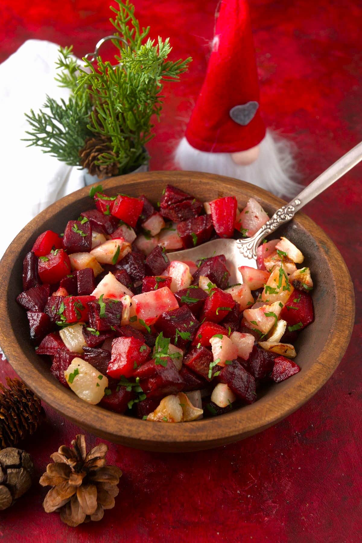 Roasted beets and turnips in wooden serving bowl with Christmas decorations.