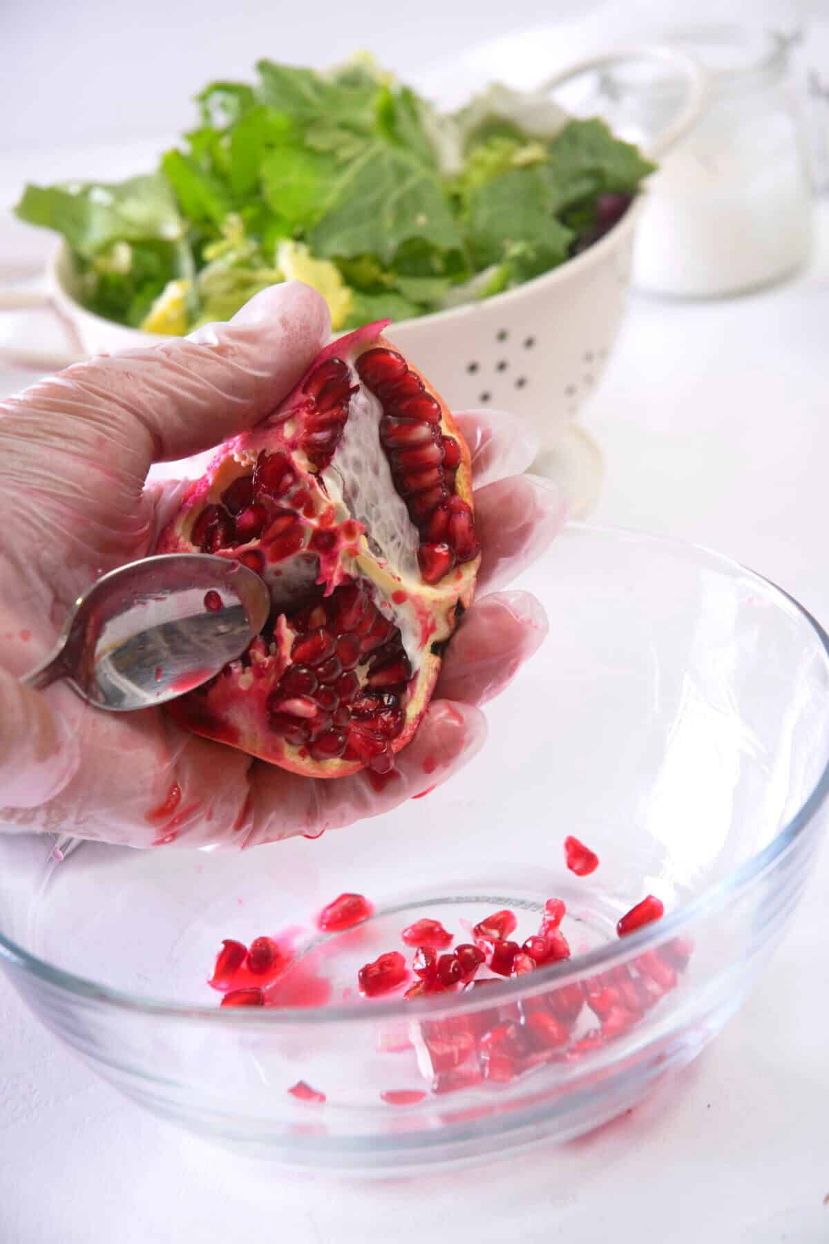 Pomegranate with seeds in a small glass bowl.