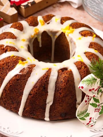 Christmas bundt cake with Christmas decorations on white plate.