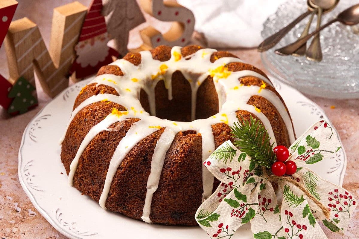 Christmas bundt cake with Christmas decorations on white plate.