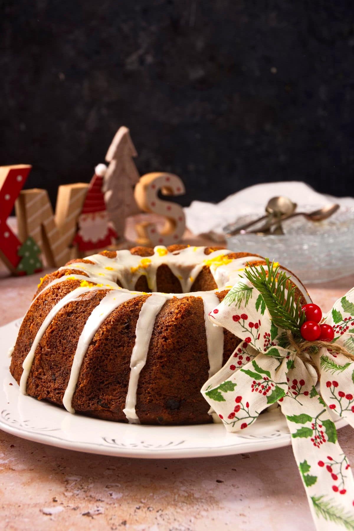 Christmas bundt cake with Christmas decorations on black background.