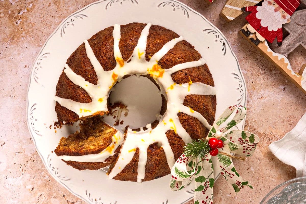 Christmas bundt cake on white plate with slice cut out.