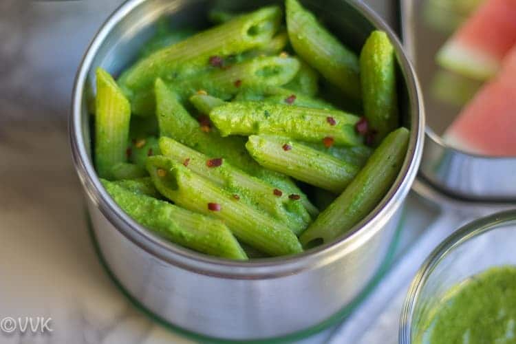 Cilantro pesto penne pasta in silver dish.