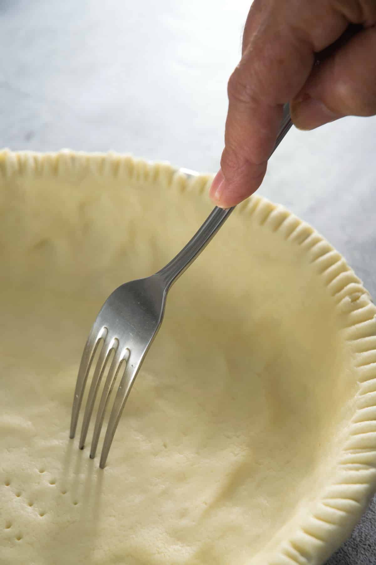 Raw pie shell with a fork.