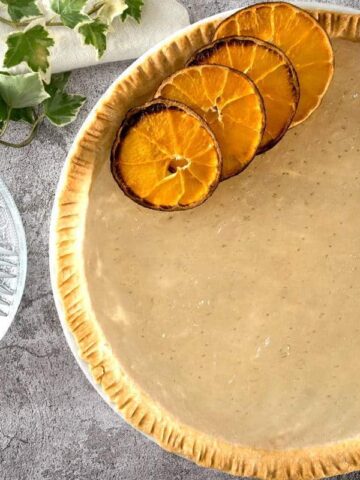 Clear pumpkin pie with dehydrated orange slices.