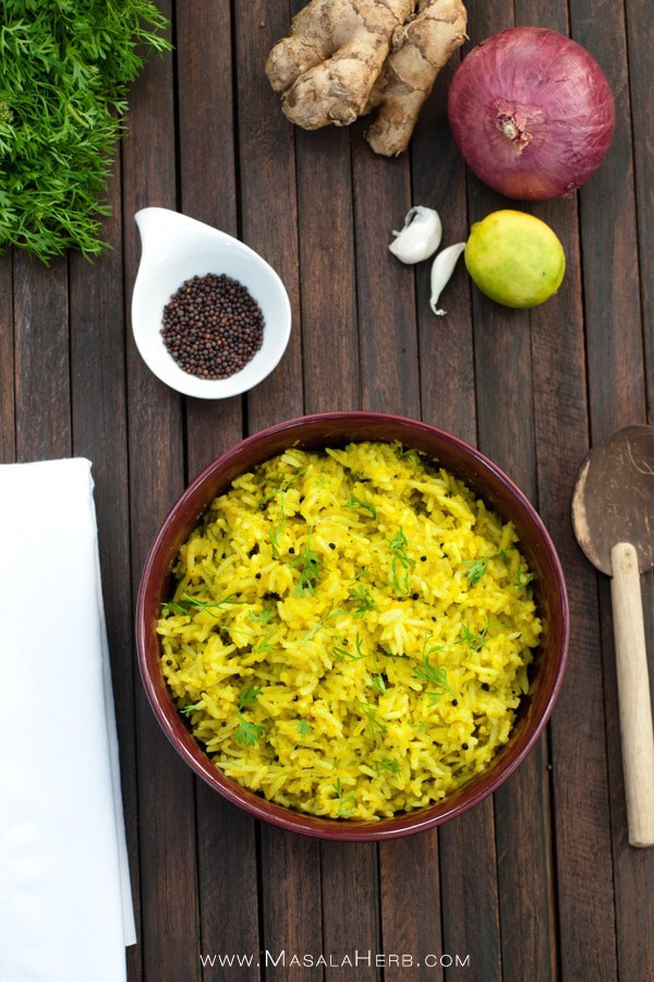 Yellow Indian rice with cilantro in a bowl on dark brown wooden background.