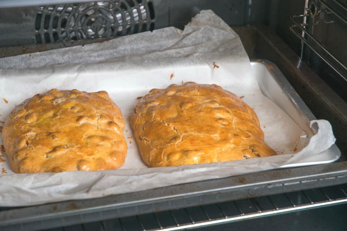 Cranberry biscotti loaves on baking sheet in oven.