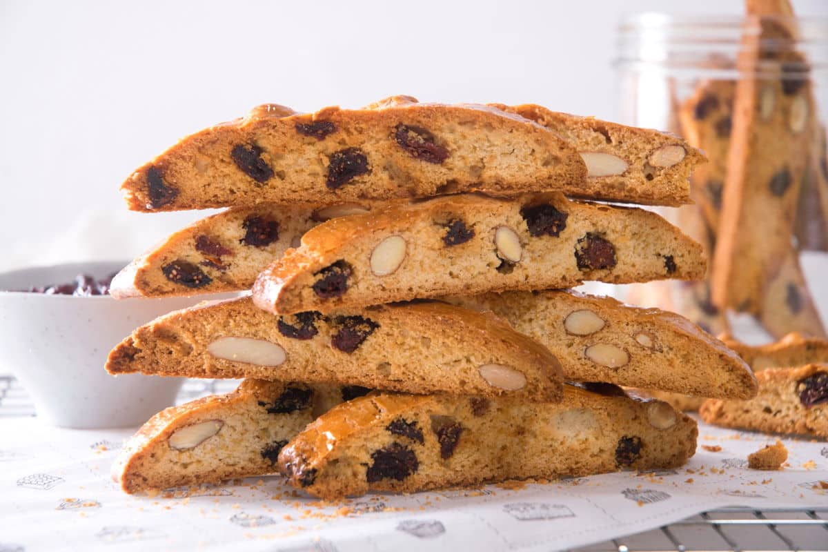 Cranberry biscotti stacked on baking rack.
