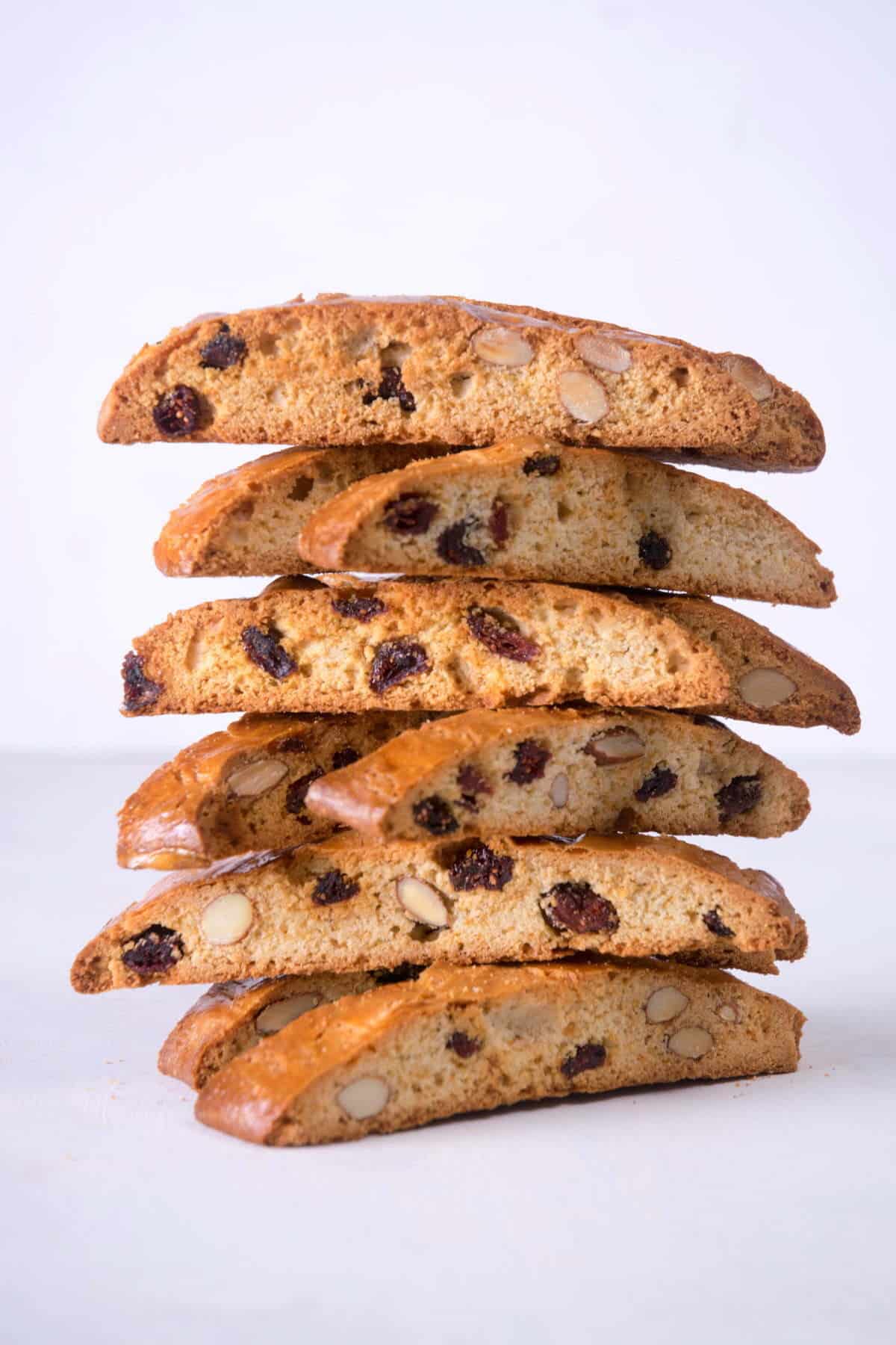 Cranberry biscotti stacked on light background.