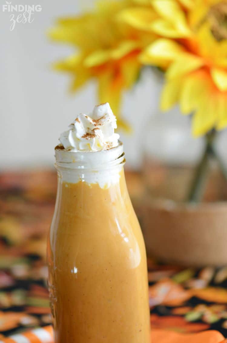 Pumpkin banana smoothie in a jar with whipped topping.