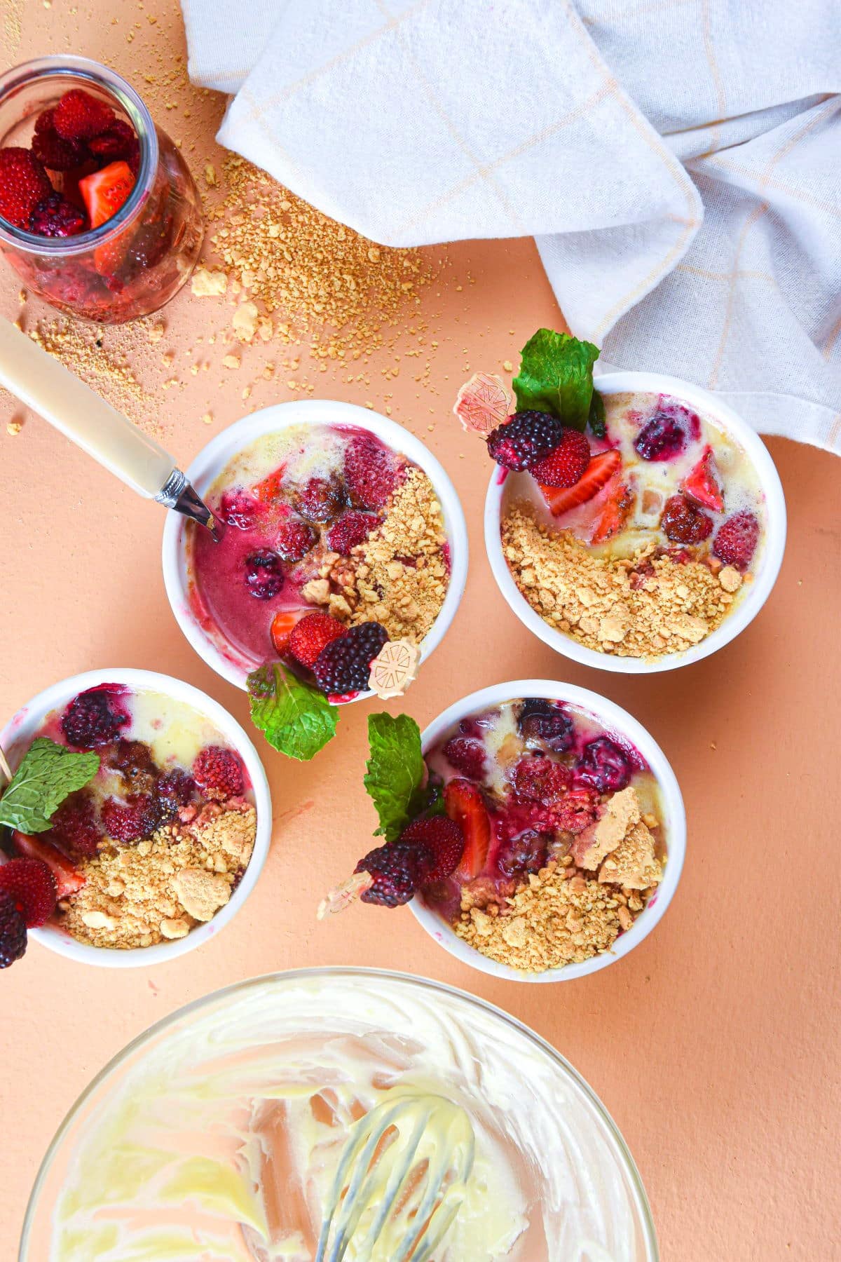 Berries and cream in ramekins with fresh mint.