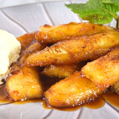 Bananas Foster on a plate with ice cream and mint leaves.