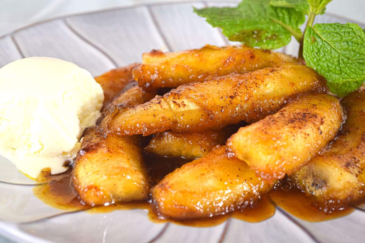 Bananas Foster on a plate with ice cream and mint leaves.