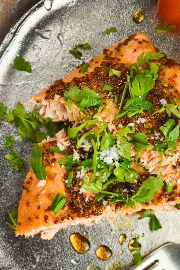 Wild salmon with fresh parsley and tomatoes on a plate.