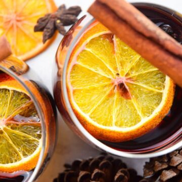 Top view of mulled wine with orange slices and cinnamon sticks.