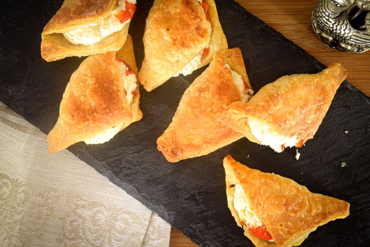 Goat cheese triangles on a black serving dish - top view.