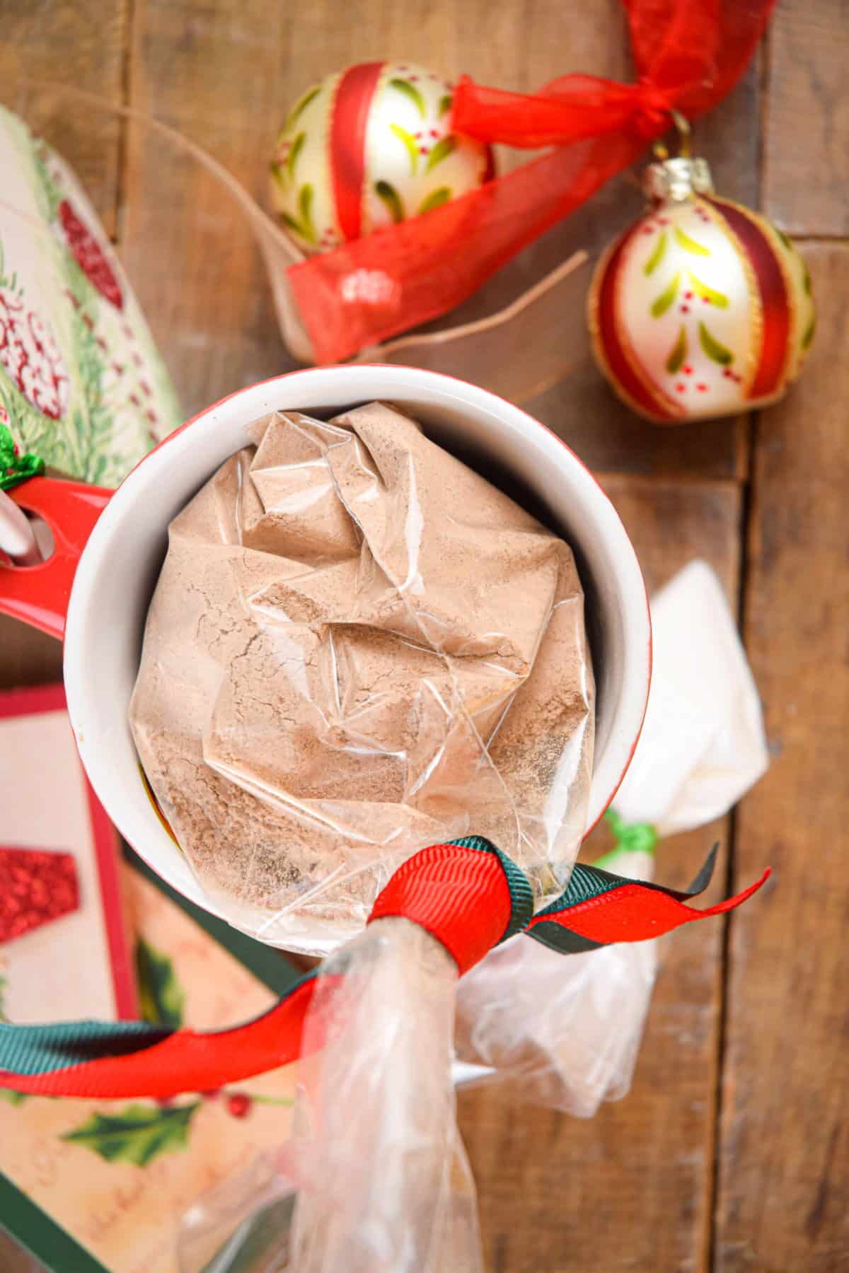 Chocolate cake ingredients packaged in a mug with Christmas decorations.