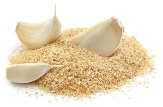 Garlic powder with garlics over white background