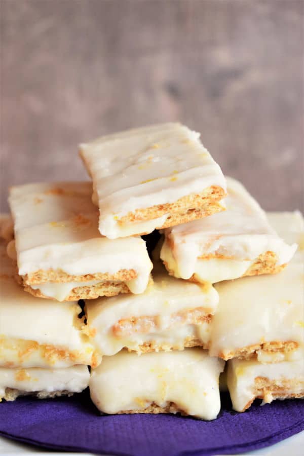 Graham wafer lemon bars on a white plate with a purple napkin.