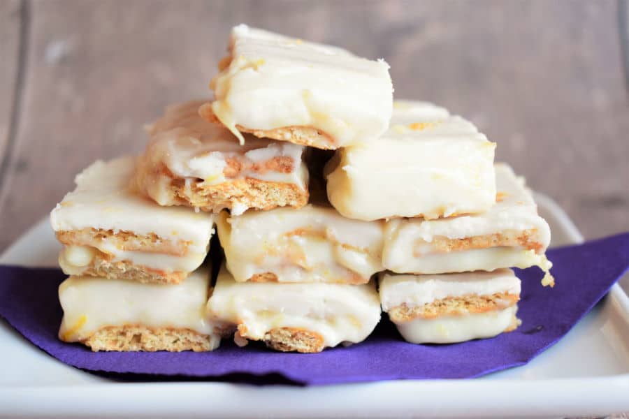 Graham wafer lemon bars on a white plate with a purple napkin.