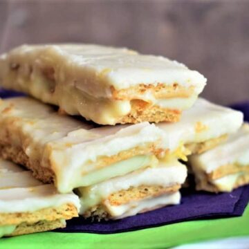 Graham wafer lemon bars on a white plate with purple and green napkins.