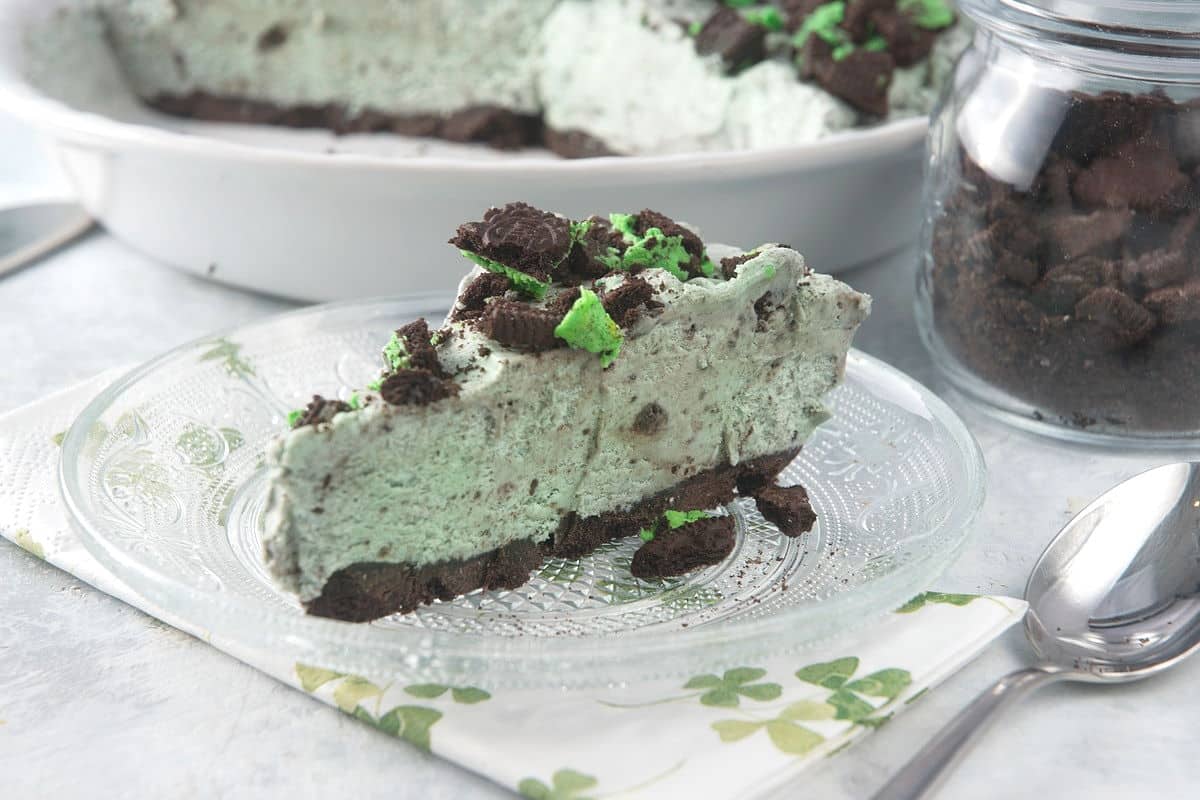 Slice of grasshopper pie on small dessert plate and a spoon on the side.