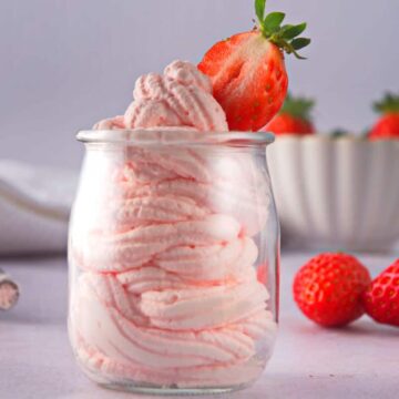 Grenadine whipped cream in glass jar with fresh strawberries.