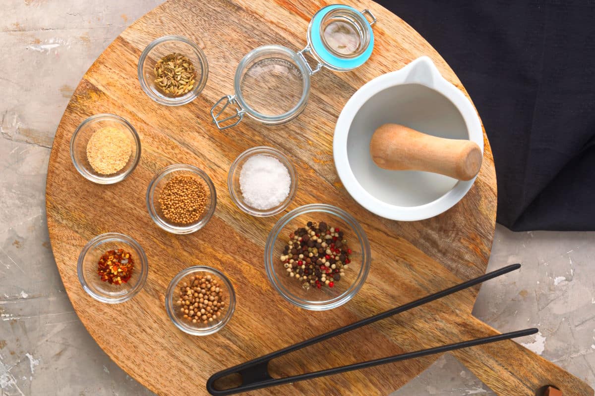 Steak rub ingredients prepped on wooden serving board.