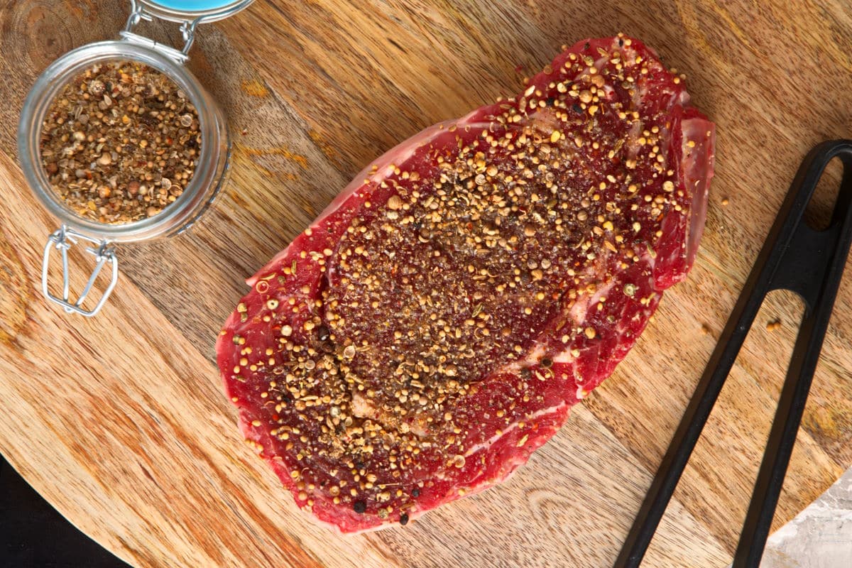 Fresh bison ribeye steak with steak rub.