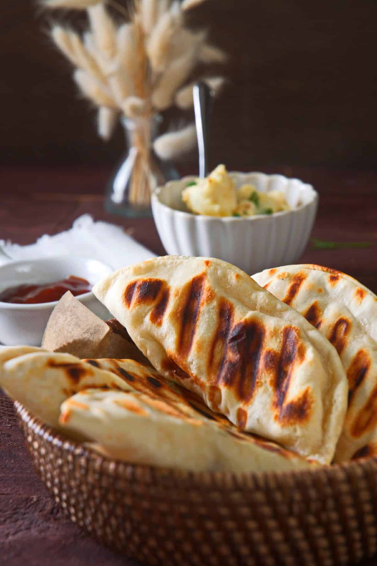 Grilled pierogies in wooden basket.