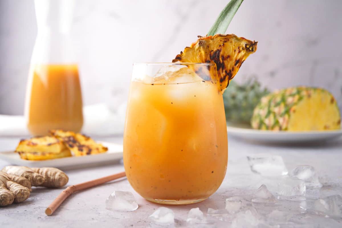 Grilled pineapple juice and wedge in glass.