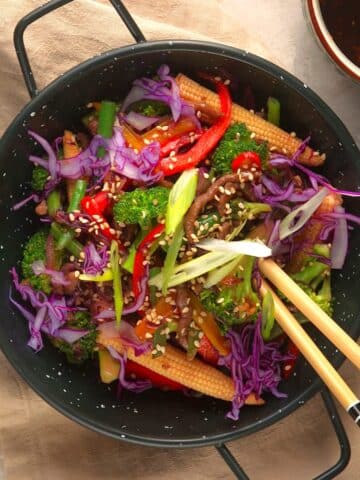 Ground beef stir fry with veggies in bowl with chopsticks.