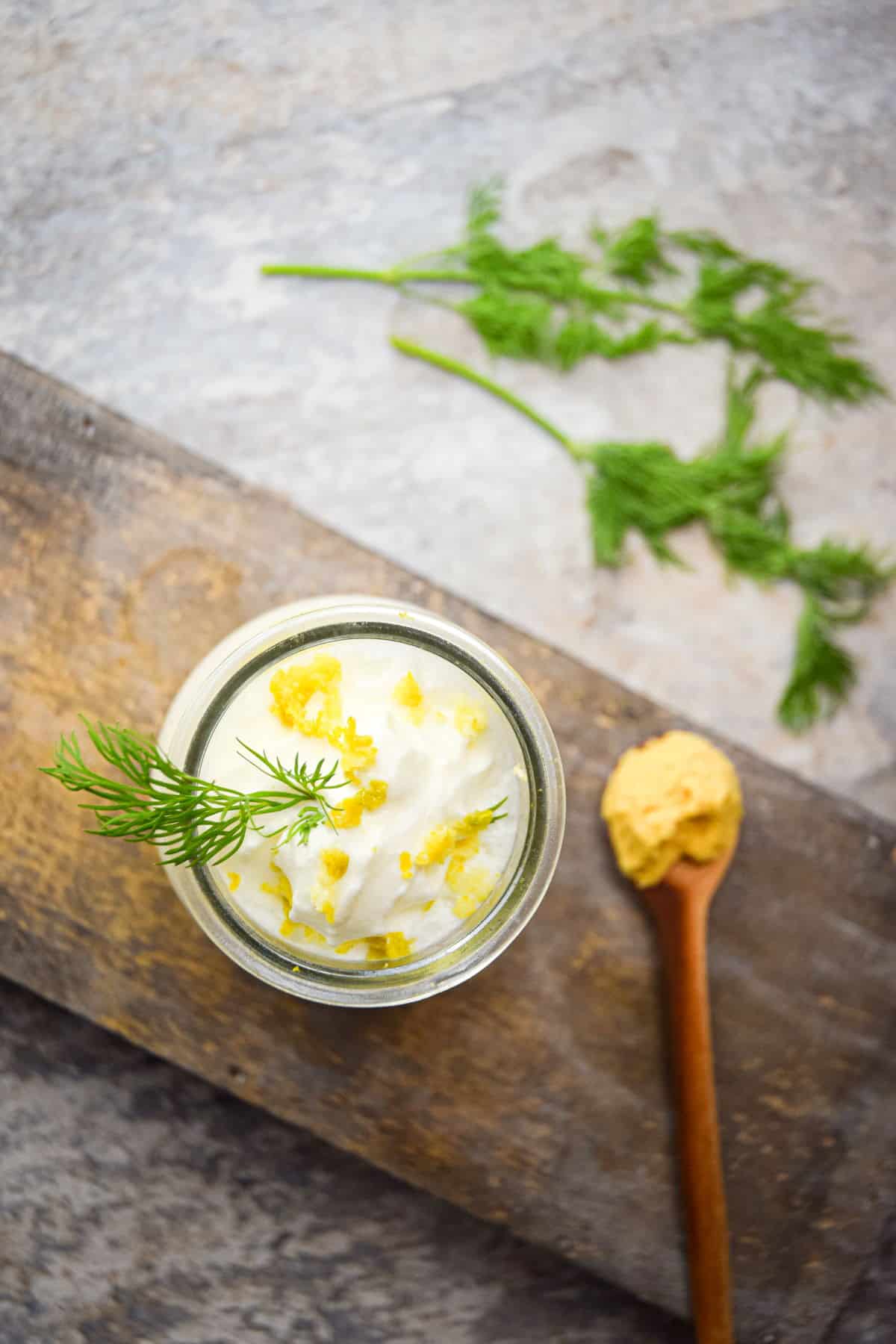 Homemade whipped topping with lemon and dill in small jar.