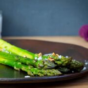 Seasoned, cooked asparagus on a plate.