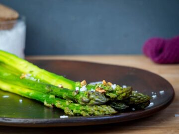 Seasoned, cooked asparagus on a plate.