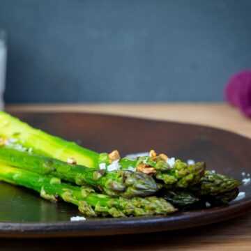 Seasoned, cooked asparagus on a plate.