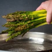 Bunch of fresh asparagus over pan.