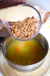 Barley in a bowl and soup in a pot.