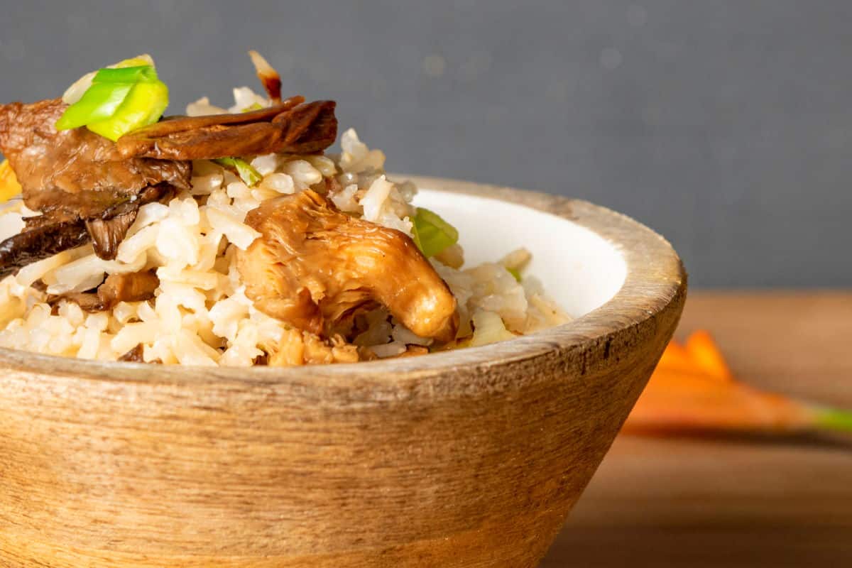 Cooked brown rice in wooden bowl.